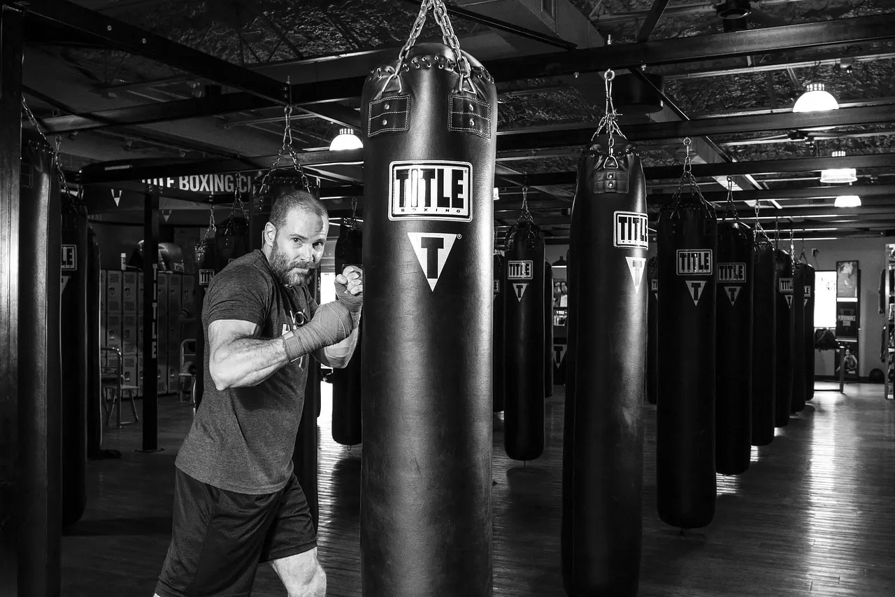 Mand der træner ved en heavybag i et boksegym